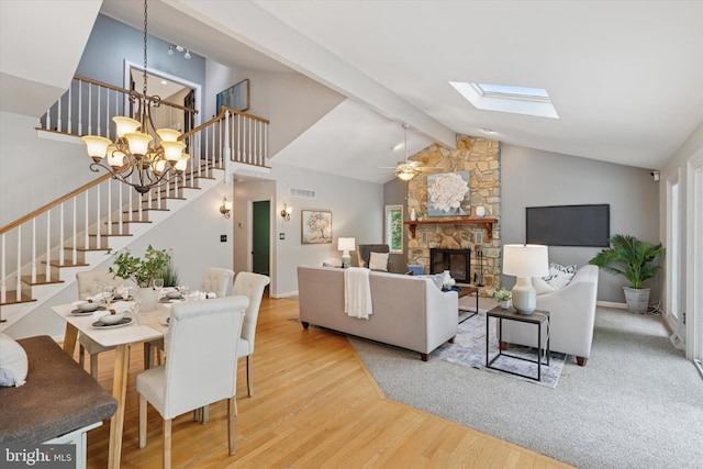 living area with stairs, wood finished floors, a chandelier, beamed ceiling, and plenty of natural light