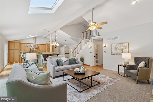 living room with stairs, baseboards, ceiling fan, a chandelier, and high vaulted ceiling
