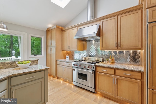 kitchen featuring designer range, wall chimney range hood, backsplash, a skylight, and light wood-style flooring