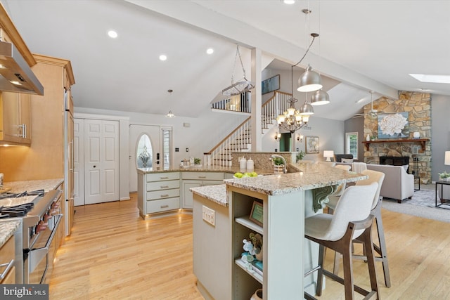 kitchen featuring stainless steel stove, light wood finished floors, a spacious island, and recessed lighting