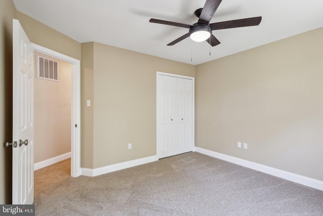 unfurnished bedroom featuring carpet flooring, a closet, baseboards, and ceiling fan