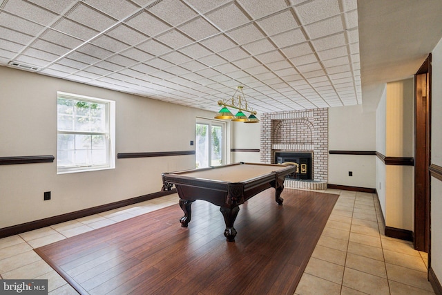 rec room with billiards table, a brick fireplace, baseboards, and light tile patterned floors