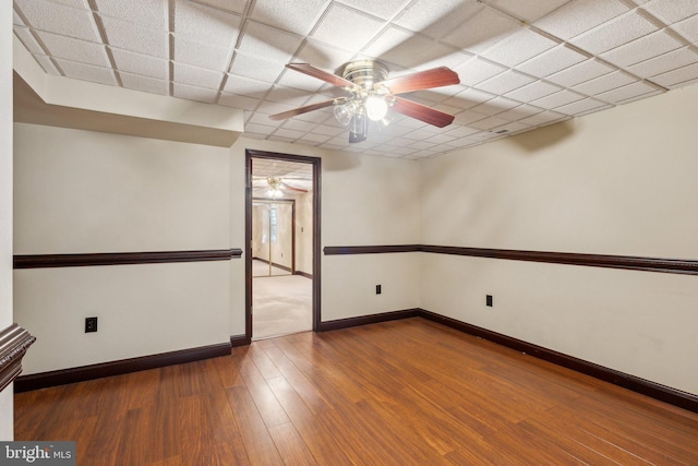 spare room with ceiling fan, wood finished floors, and baseboards
