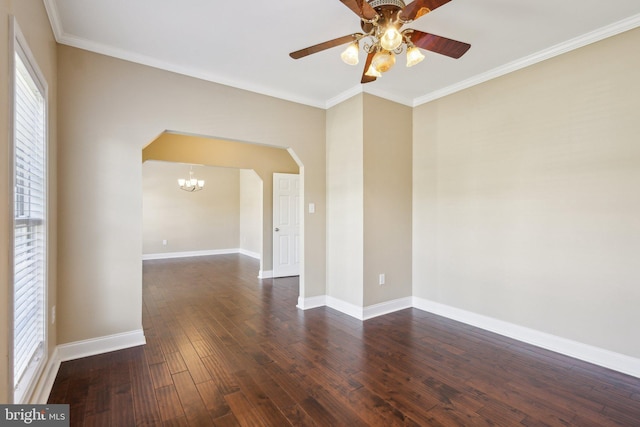 empty room featuring dark wood-style flooring, ceiling fan, arched walkways, ornamental molding, and baseboards
