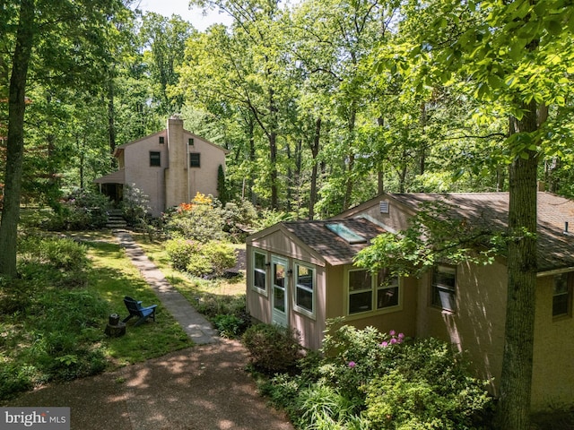 view of property exterior with roof with shingles and stucco siding