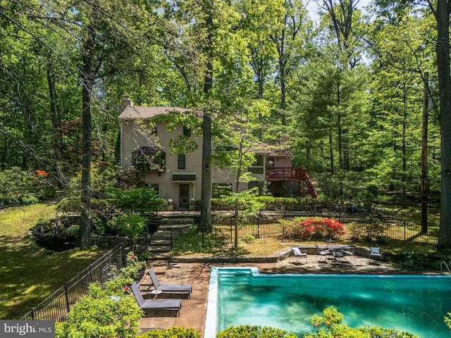 view of pool with stairway, fence, and a patio area