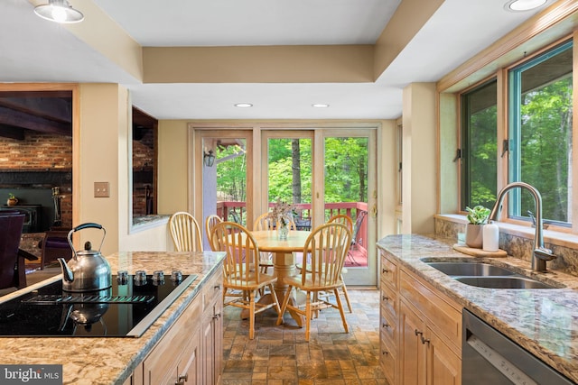 kitchen featuring a sink, black electric cooktop, dishwasher, plenty of natural light, and recessed lighting