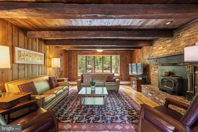 living room with hardwood / wood-style flooring, wooden walls, beam ceiling, wooden ceiling, and a wood stove