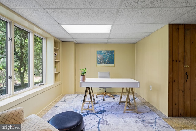 home office featuring a drop ceiling and built in shelves