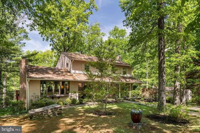 view of front of home featuring a chimney and stucco siding