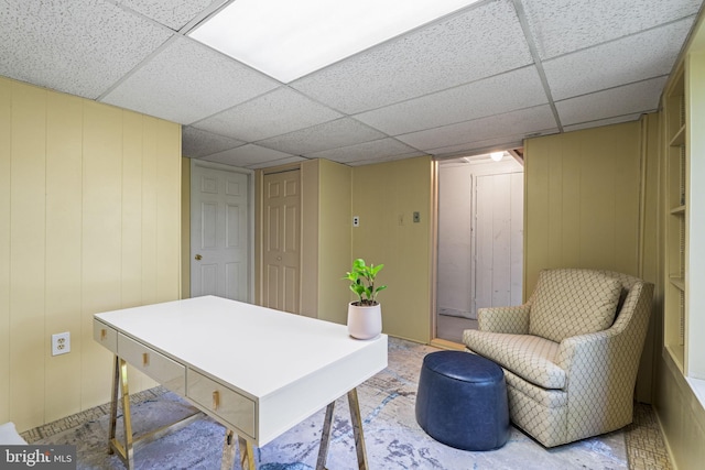 office area with a paneled ceiling and a decorative wall