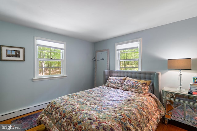 bedroom with wood finished floors and baseboard heating