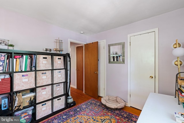 bedroom featuring wood finished floors and baseboards