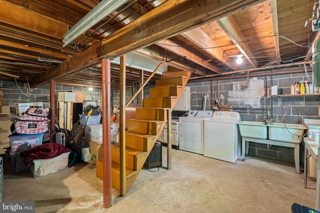 unfinished basement featuring independent washer and dryer, stairs, and a sink