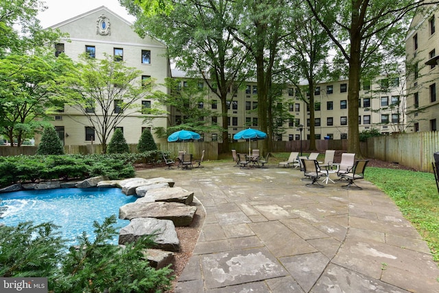 swimming pool with a fenced backyard, a patio area, and outdoor dining space