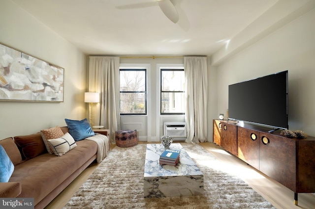 living room featuring ceiling fan, light wood-style flooring, and a wall unit AC