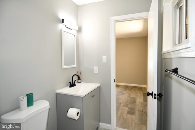1210 Lindsay Rd, Oxon Hill, MD 20745 - half bath featuring vanity, wood finished floors, toilet, and baseboards