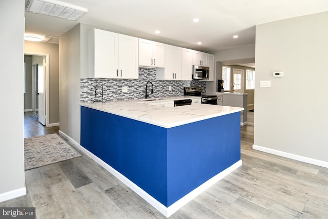 1210 Lindsay Rd, Oxon Hill, MD 20745 - kitchen featuring stainless steel appliances, a sink, light wood-type flooring, light stone countertops, and a peninsula