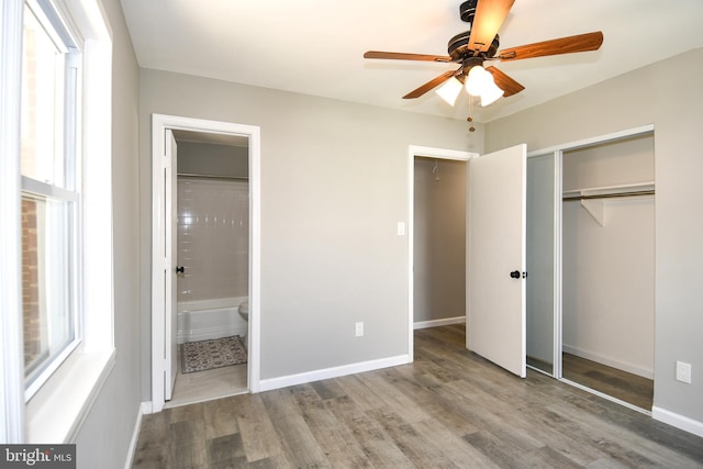 1210 Lindsay Rd, Oxon Hill, MD 20745 - unfurnished bedroom featuring wood finished floors, a closet, multiple windows, and connected bathroom