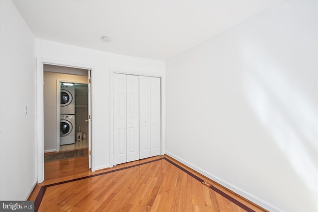 1233 Boucher Ave, Annapolis, MD 21403 - unfurnished bedroom featuring estacked washer and dryer, light wood-style floors, baseboards, and a closet