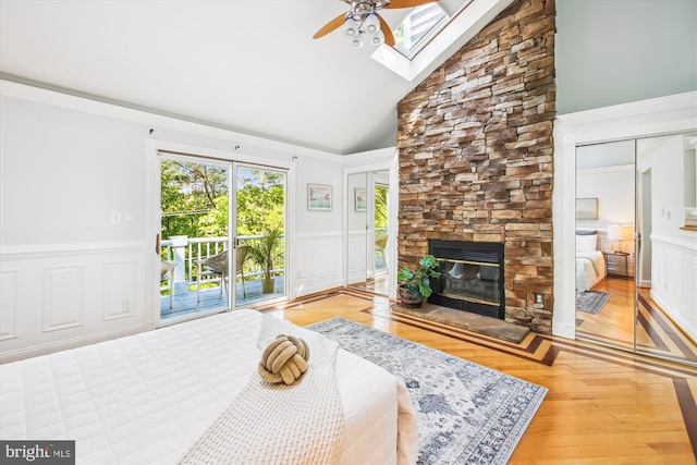 1233 Boucher Ave, Annapolis, MD 21403 - bedroom with access to exterior, a stone fireplace, wood finished floors, a decorative wall, and wainscoting