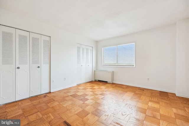 unfurnished bedroom featuring multiple closets and baseboards