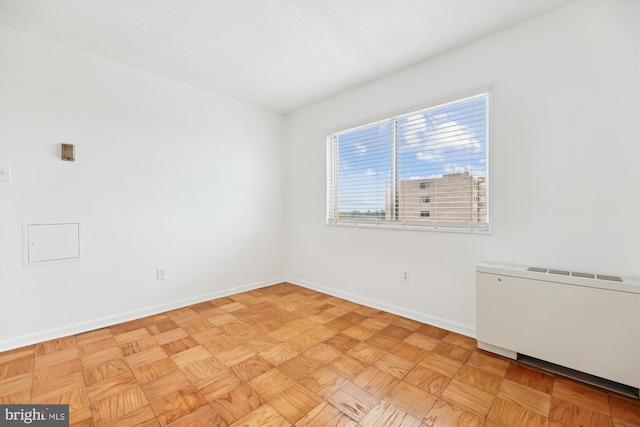 spare room with radiator and baseboards