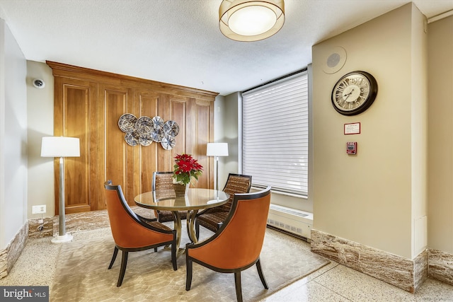 dining space featuring dark aggregate flooring and baseboards