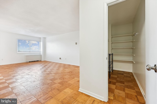 unfurnished room featuring baseboards and radiator