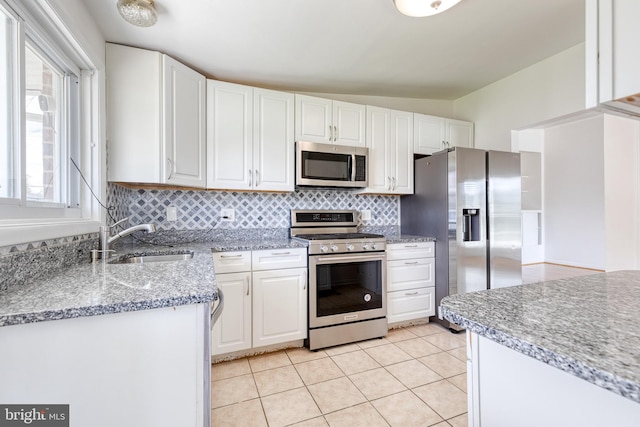 kitchen featuring stainless steel appliances, a sink, and white cabinetry