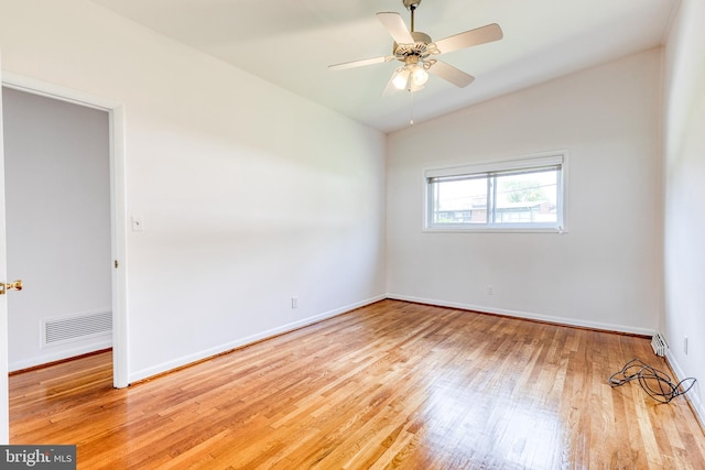 empty room featuring wood finished floors, baseboards, and a ceiling fan