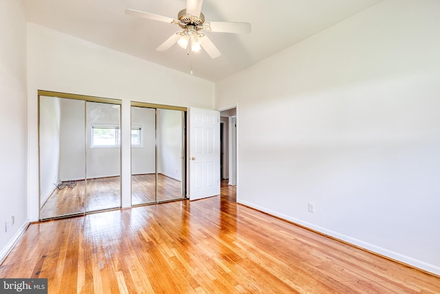 unfurnished bedroom with multiple closets, light wood-type flooring, and baseboards