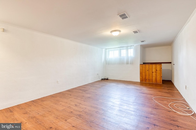 unfurnished room with wood finished floors and ornamental molding