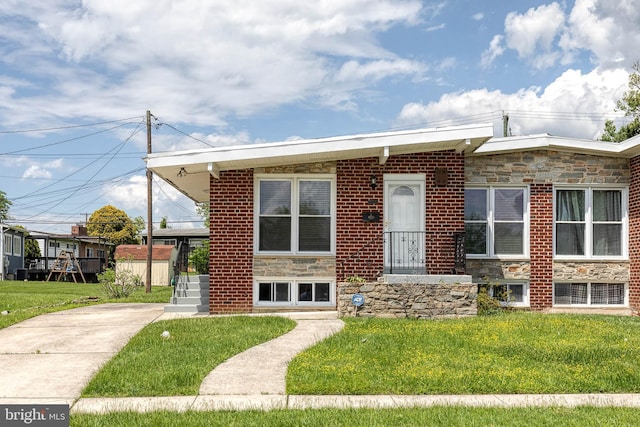 bungalow featuring a front lawn and stone siding