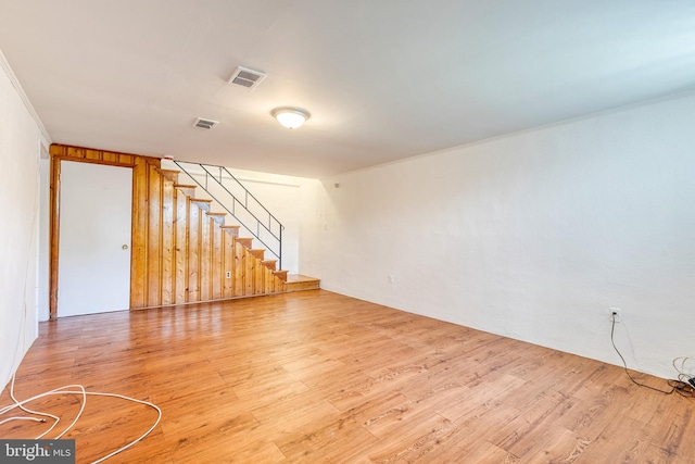 unfurnished living room with light wood finished floors, stairway, and ornamental molding