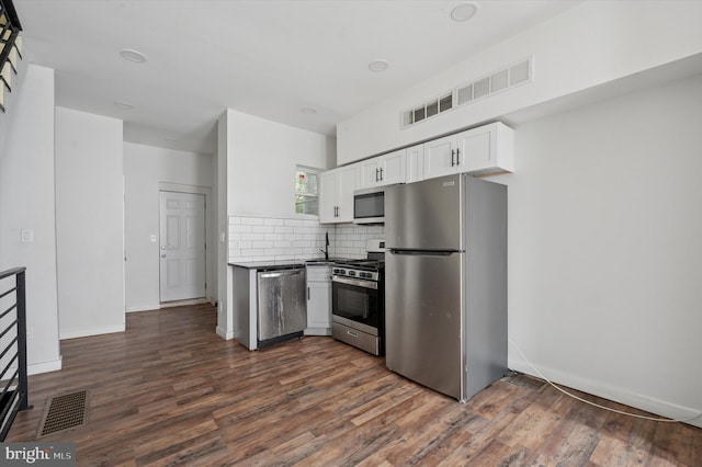 2214 N Cleveland St, Philadelphia, PA 19132 - kitchen featuring appliances with stainless steel finishes, white cabinets, tasteful backsplash, dark wood-style floors, and baseboards
