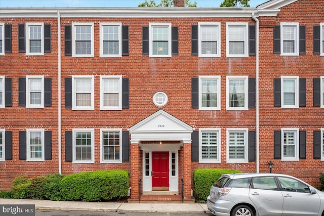 multi unit property with brick siding and a chimney