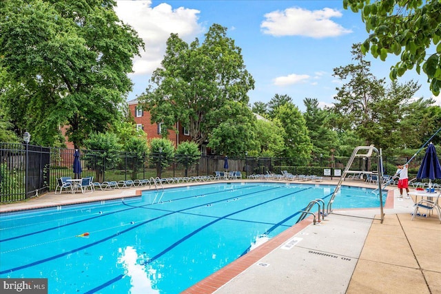 community pool with fence and a patio