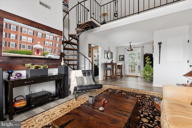 living room featuring wood finished floors, stairs, and a towering ceiling
