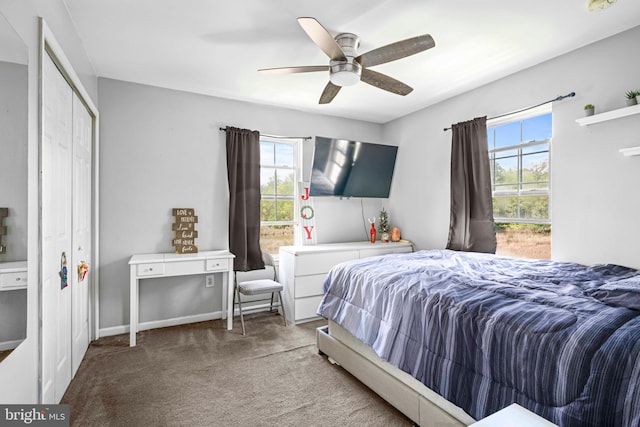 carpeted bedroom with a closet, a ceiling fan, and baseboards