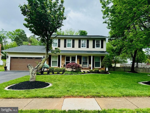 view of front of property featuring asphalt driveway, an attached garage, and covered porch