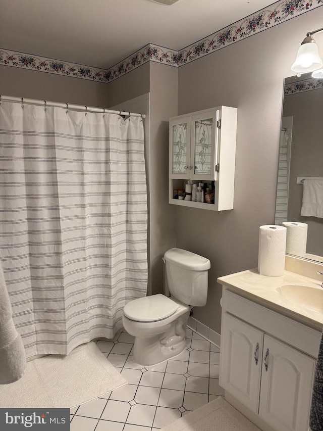 bathroom with toilet, vanity, tile patterned floors, and curtained shower