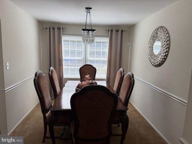dining room with carpet, baseboards, and a chandelier