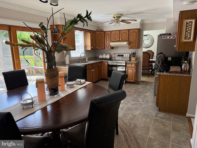 kitchen with electric stove, brown cabinetry, a sink, ceiling fan, and ornamental molding