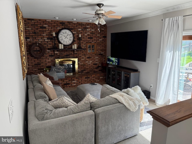 carpeted living room with ceiling fan, a brick fireplace, ornamental molding, and baseboards