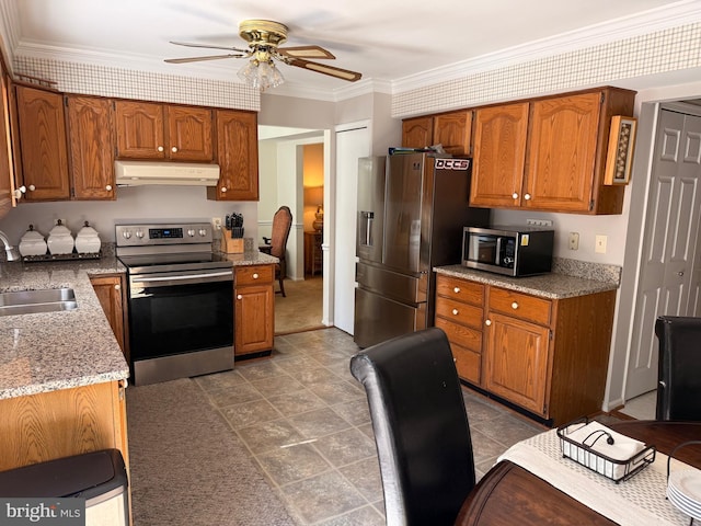 kitchen with stainless steel appliances, a sink, under cabinet range hood, ceiling fan, and brown cabinets