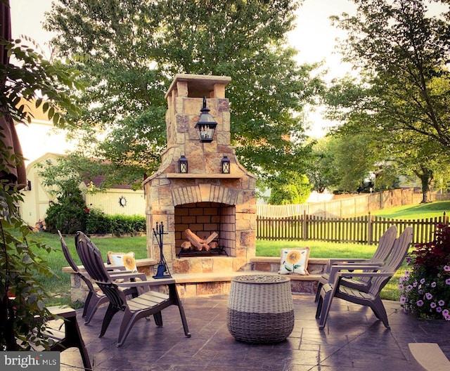 view of patio with an outdoor stone fireplace and fence