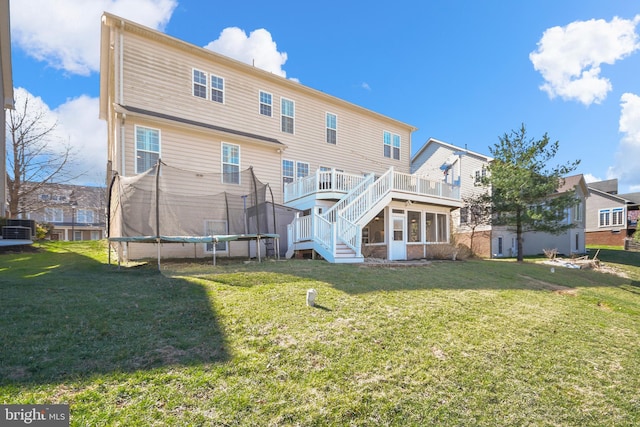 4108 Brushfield Dr, Frederick, MD 21704 - back of house with a trampoline, stairs, a lawn, and a wooden deck