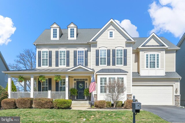 4108 Brushfield Dr, Frederick, MD 21704 - view of front of house with covered porch, a standing seam roof, driveway, an attached garage, and stone siding