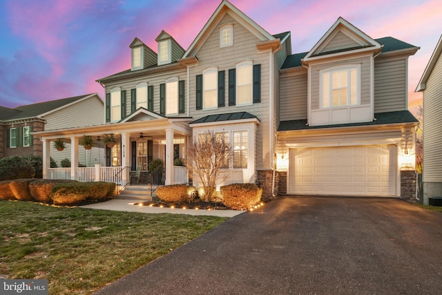 4108 Brushfield Dr, Frederick, MD 21704 - view of front facade with a porch, stone siding, asphalt driveway, and an attached garage